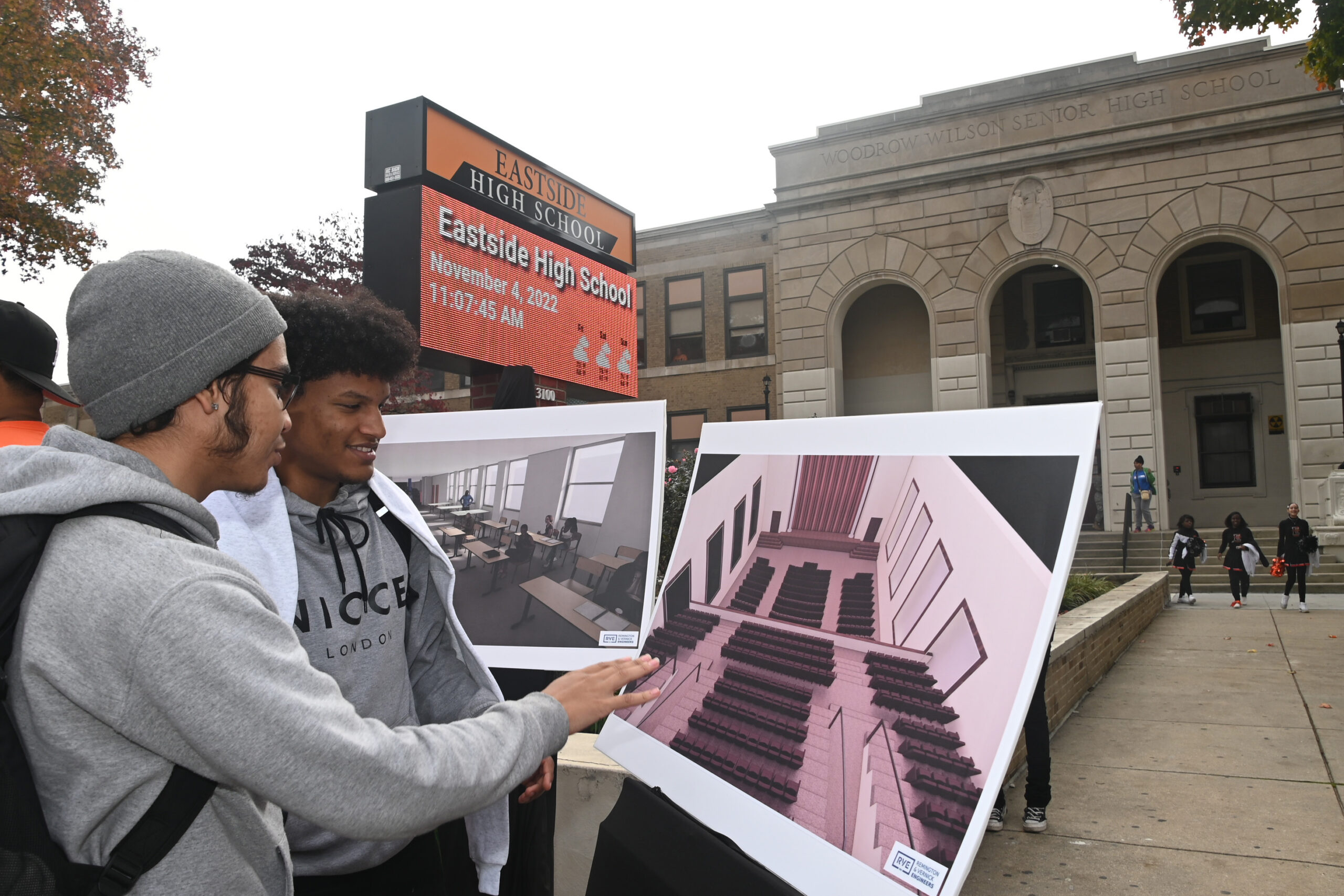Camden Eastside HS juniors Elijah Jimenez (left), and Cristian Cabrera, look over architectural renderings of some of the planned $41million grant announced Friday.  They're in front of the the  school building on Federal St. in Camden, NJ, on Friday, Nov. 4, 2022. The electronic sign is part of the upgrades.